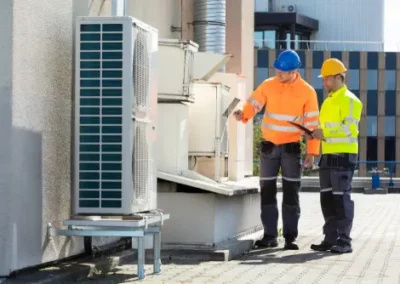 Two men working on a rooftop commercial HVAC system